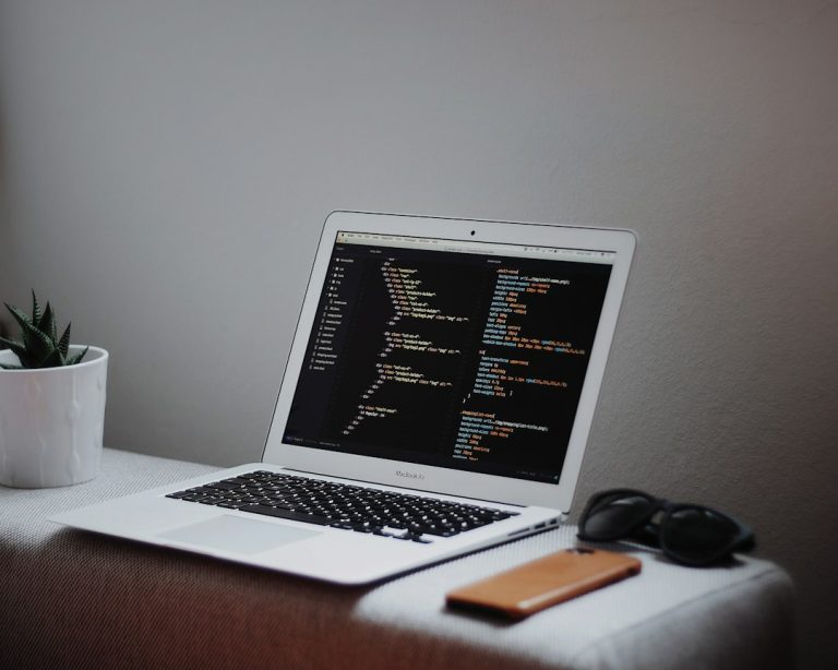 Computador portátil exibindo código de programação, imagem ilustrativa sobre tecnologia e pesquisa universitária