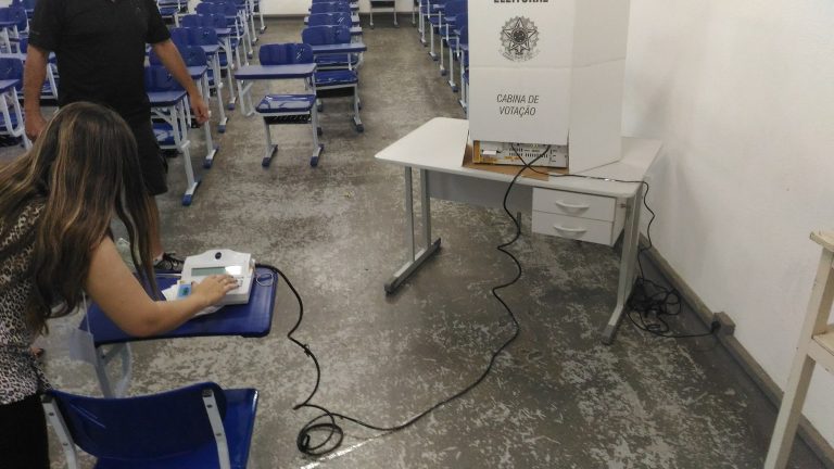 MP Eleitoral acompanha denúncias sobre transporte e celulares no segundo turno na Paraíba Mesária opera terminal da urna eletrônica em local de votação durante eleições municipais de 2016, em Itajubá, Minas Gerais. Foto: Mateus S. Figueiredo / Wikimedia Commons, CC BY-SA 4.0.