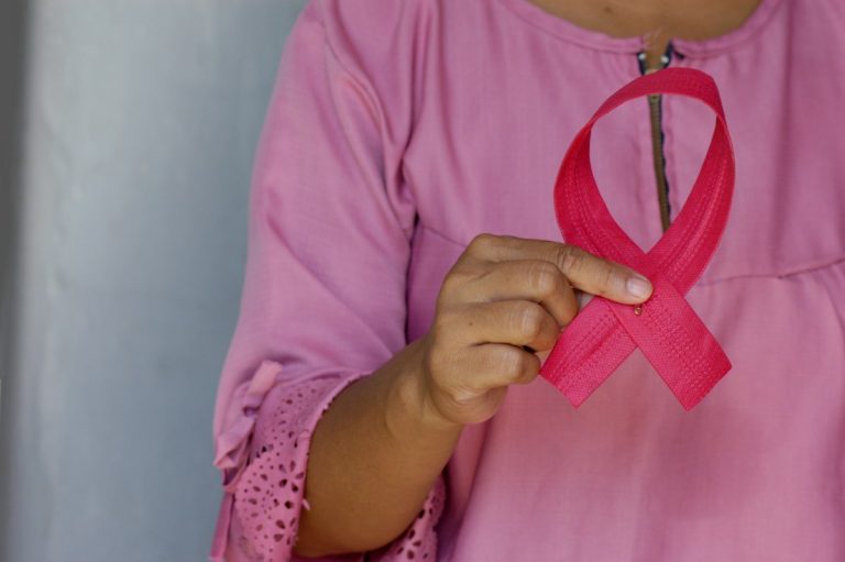Inca lança estudo sobre desigualdades raciais no câncer de mama durante Outubro Rosa Mulher segura laço rosa de conscientização sobre câncer de mama, imagem ilustrativa de Angiola Harry