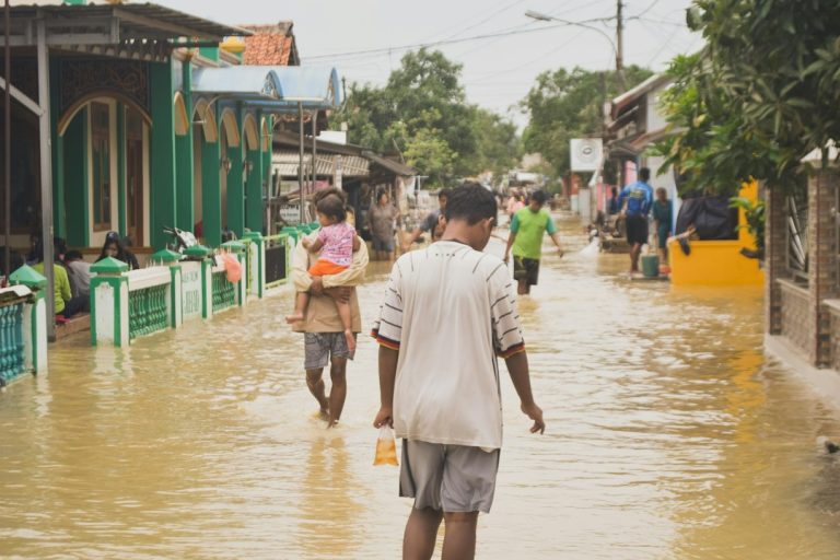 Pessoas caminhando na rua, imagem ilustrativa de riscos climáticos